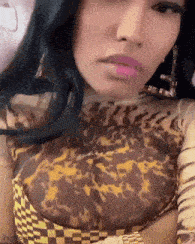 a woman wearing a leopard print top and earrings is looking at the camera .