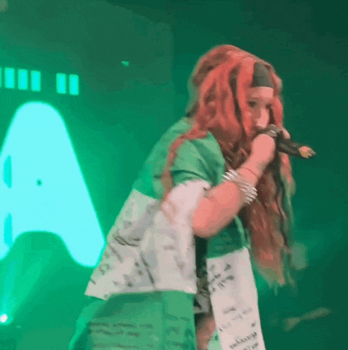 a woman with red hair is singing into a microphone on a stage