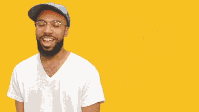 a man wearing glasses and a blue hat stands in front of a yellow background that says yes lawd