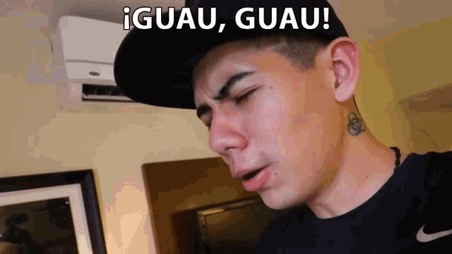 a man wearing a black hat and a black nike shirt says iguau guau