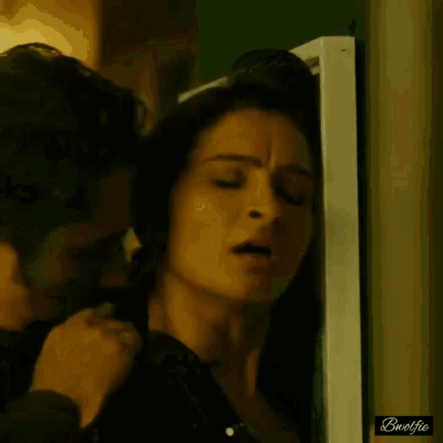 a man is kissing a woman on the neck while she is closed her eyes .