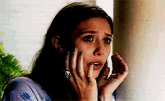a woman with a surprised look on her face is holding her hands to her face