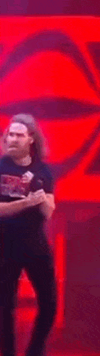 a man with a beard is dancing on a stage with a microphone in his hand .