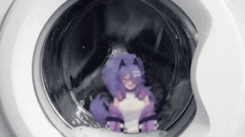 a purple stuffed animal is sitting in the washing machine .