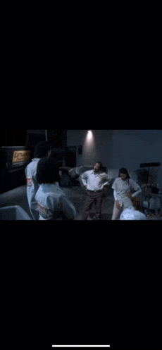 a group of people are standing in a dark room with their arms outstretched .