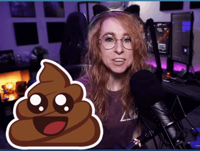 a woman stands in front of a microphone next to a sticker of a poop