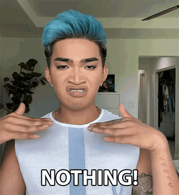 a man with blue hair is making a face and the word nothing is on his chest
