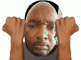 a man with a bald head and a beard is holding his fists up in front of his face .
