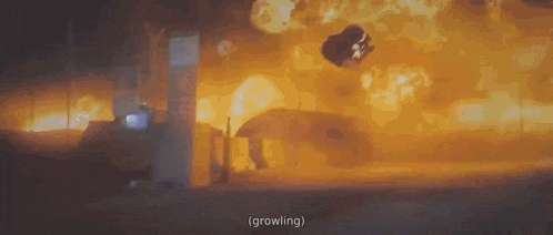a person is flying through the air in front of a large explosion .