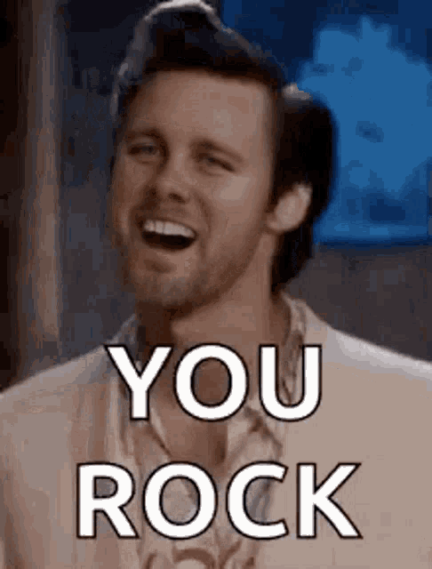 a man with a beard is laughing and saying `` you rock '' .