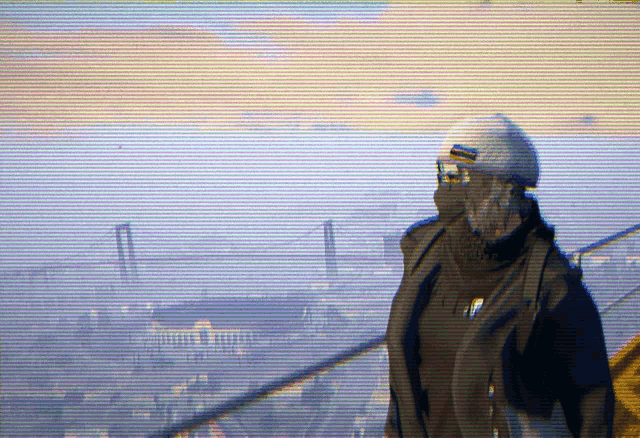 a man wearing a helmet and goggles is standing on a balcony overlooking a city