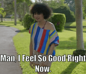 a woman in a striped shirt is walking down a sidewalk and says man i feel so good right now
