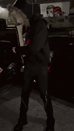 a man standing in front of a car with a hoodie that says samurai