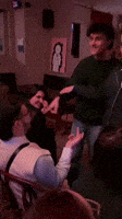 a group of people are gathered in a room with a penguin on the wall