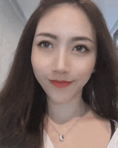 a close up of a woman 's face with a necklace on