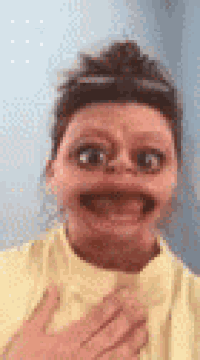 a woman wearing a yellow shirt is making a funny face with her mouth open .