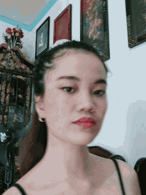 a woman in a black tank top looks at the camera