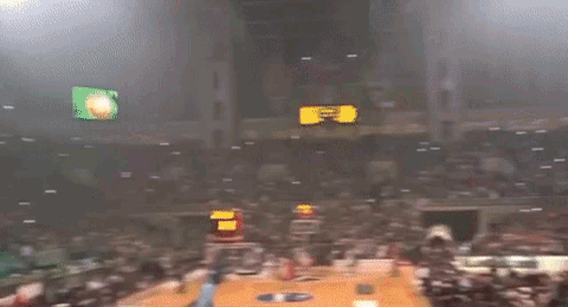 a crowd of people in a stadium with smoke coming out of the stands and a sign that says ' a '