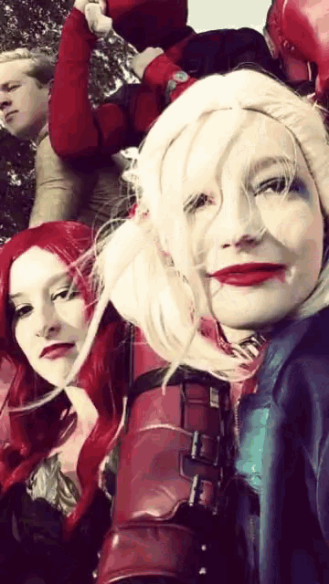 a woman in a harley quinn costume takes a selfie with two other women