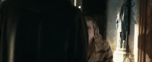 a man and a woman are looking at each other in front of a mirror
