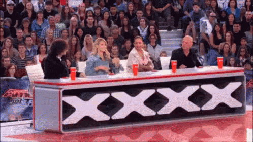 a group of people are sitting at a table with a sign that says xxx
