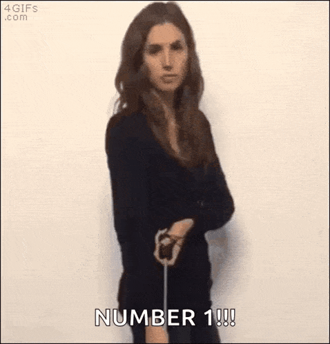 a woman in a black dress is holding a sword and says number 1 !