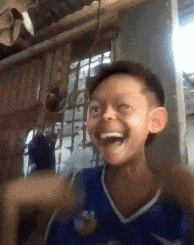 a young boy wearing a blue nike shirt is laughing