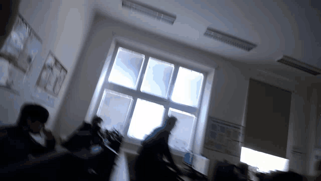 a blurry picture of people in a classroom with a sign on the wall that says ' a '