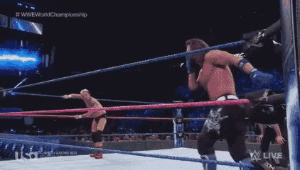 a wrestling match is taking place in a ring with a referee watching .