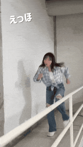 a woman in a plaid shirt and ripped jeans is running down a staircase
