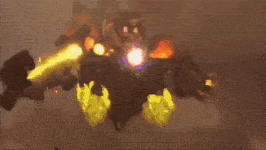 a robot is holding a shield that is surrounded by flames and a laser beam .