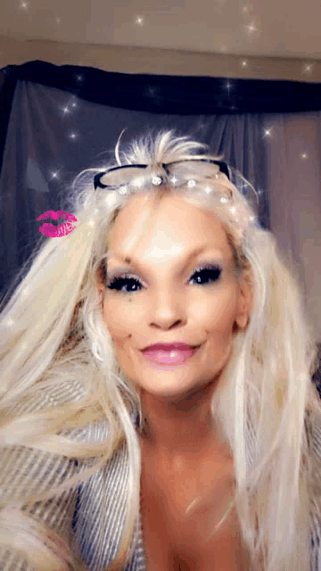 a woman with blonde hair and glasses has a pink kiss on her cheek