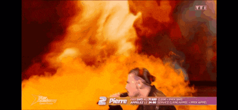 a man singing in front of a fire with the number 2 pierre on the bottom right