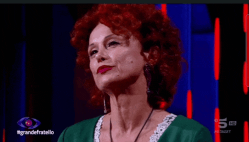 a woman with red hair and a green dress is on a television screen