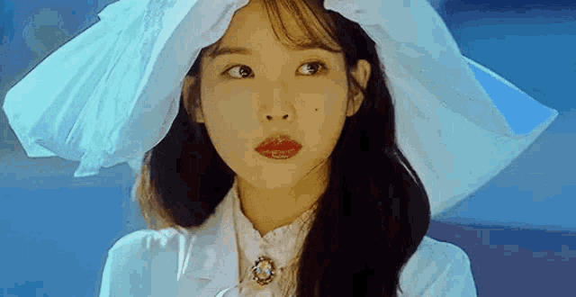 a close up of a woman wearing a white hat and a white dress .