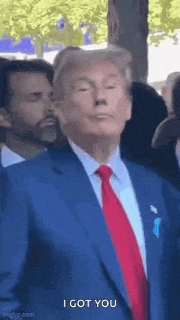 a man in a suit and tie is standing in front of a crowd .