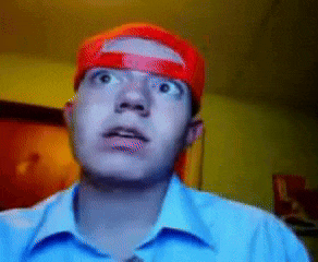 a man wearing a blue shirt and a red hat is looking up