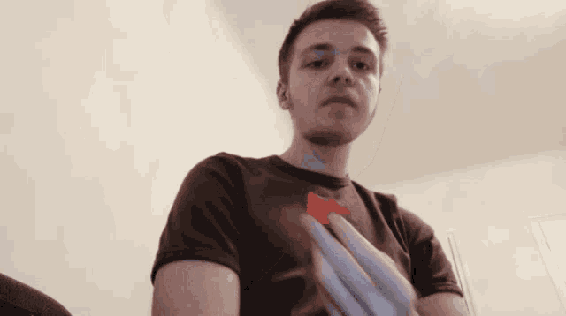 a man in a brown shirt is holding a piece of paper in his hand