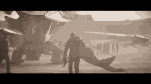 a man is carrying another man on his back while walking in front of a plane .