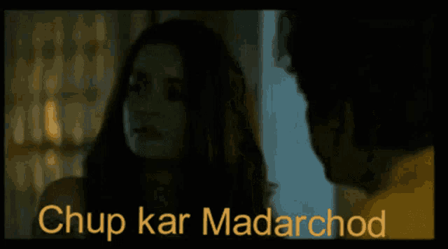 a man and a woman are looking at each other in a dark room in a movie .