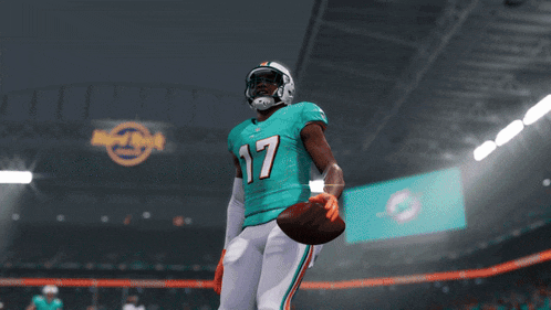 a miami dolphins football player stands in front of a touchdown banner