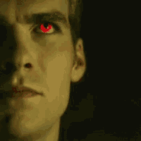 a man with red eyes is looking at the camera .