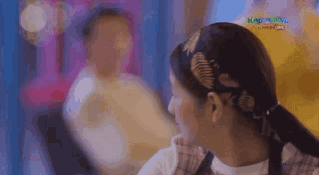 a woman wearing a headband with leaves on it looks to the side