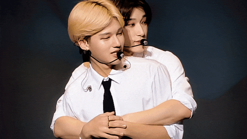 two men hugging each other and one has a microphone on his head