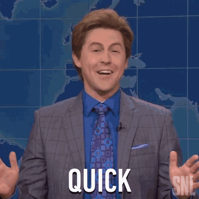 a man in a suit and tie is making a quick gesture