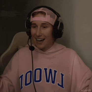 a person wearing headphones and a pink hoodie that says 100wj on it