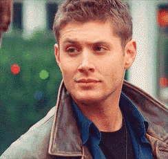 a man wearing a brown leather jacket and a blue shirt looks at the camera .