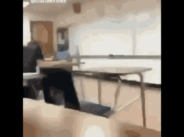 a blurry picture of a classroom with people sitting at desks