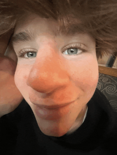 a close up of a person 's face with red cheeks