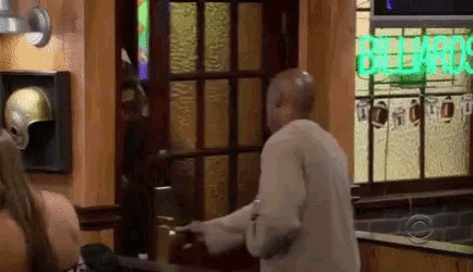 a man is standing in front of a billiards sign .